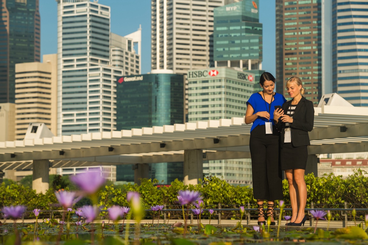 Two women looking at the phone in the city