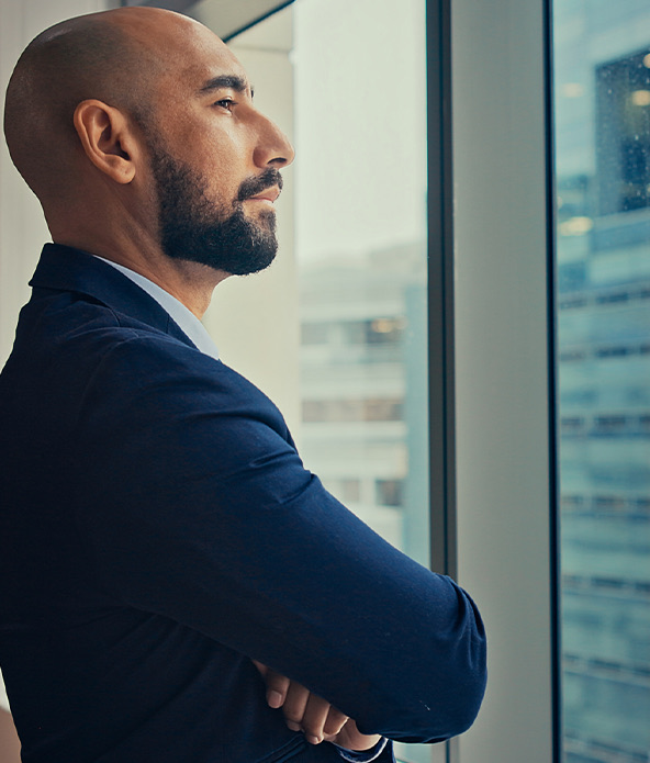 Man stands and looks by the window