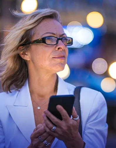 Woman holds phone and looking away
