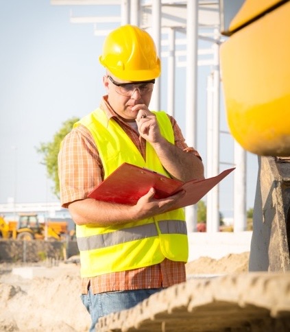 Construction worker reading documents on a construction site