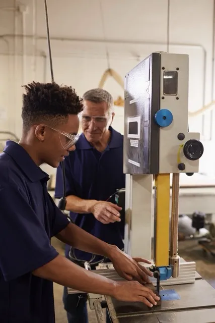 The master teaches the apprentice in the workshop