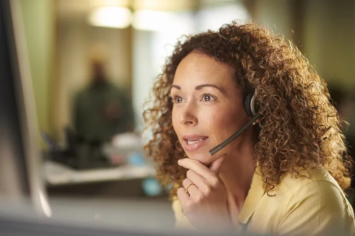 Call center wroker talks and looks at the screen
