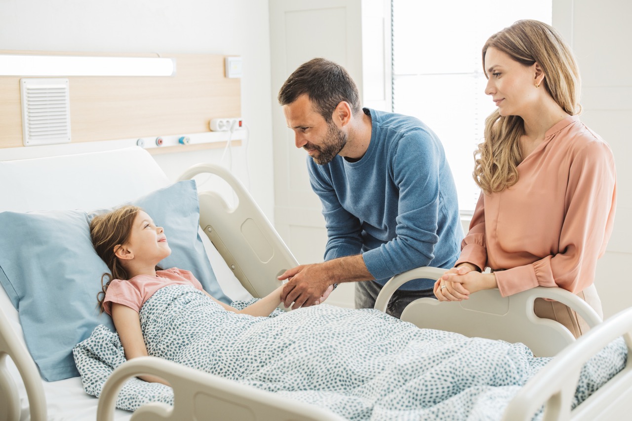 Parents watching over their daughter lying in hospital