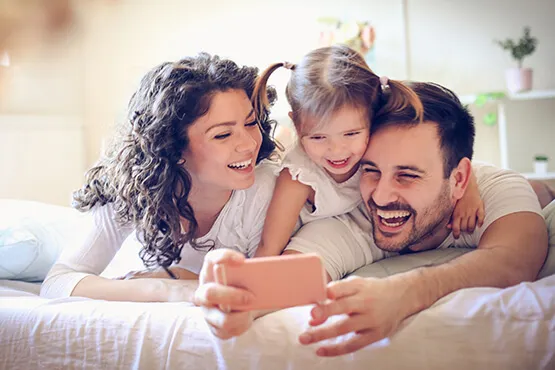 Photo of a family watching a phone video